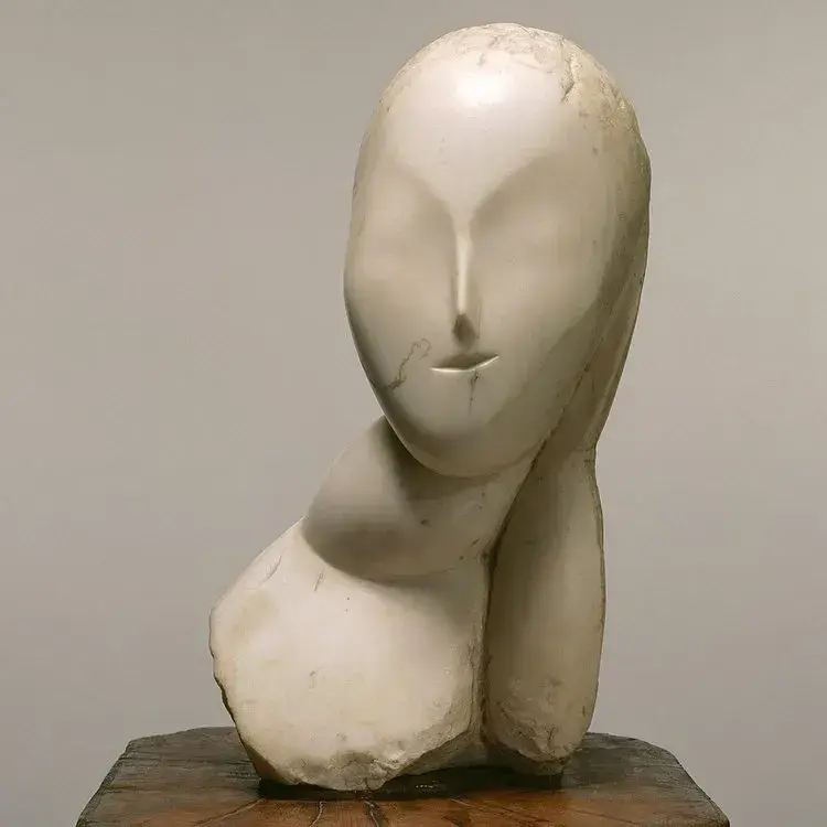 Sculpture en marbre représentant un visage stylisé avec des formes douces et épurées.