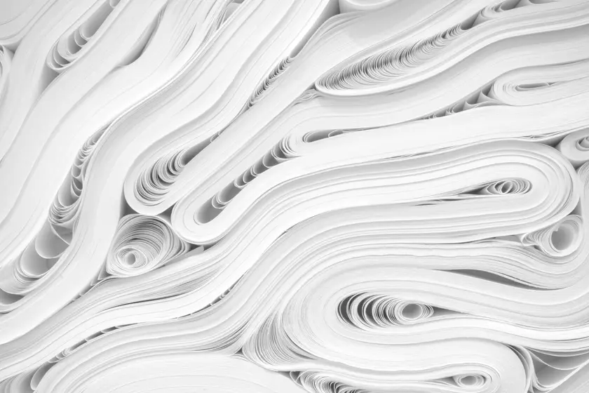 Des feuilles de papier blanches disposées en ondulations et en courbes.